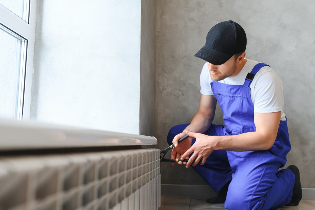 Heating system installation maintenance service plumber installing radiator